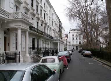 cars parked by the white building in London, England